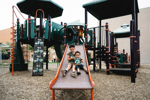 two children on slide in outdoor playground